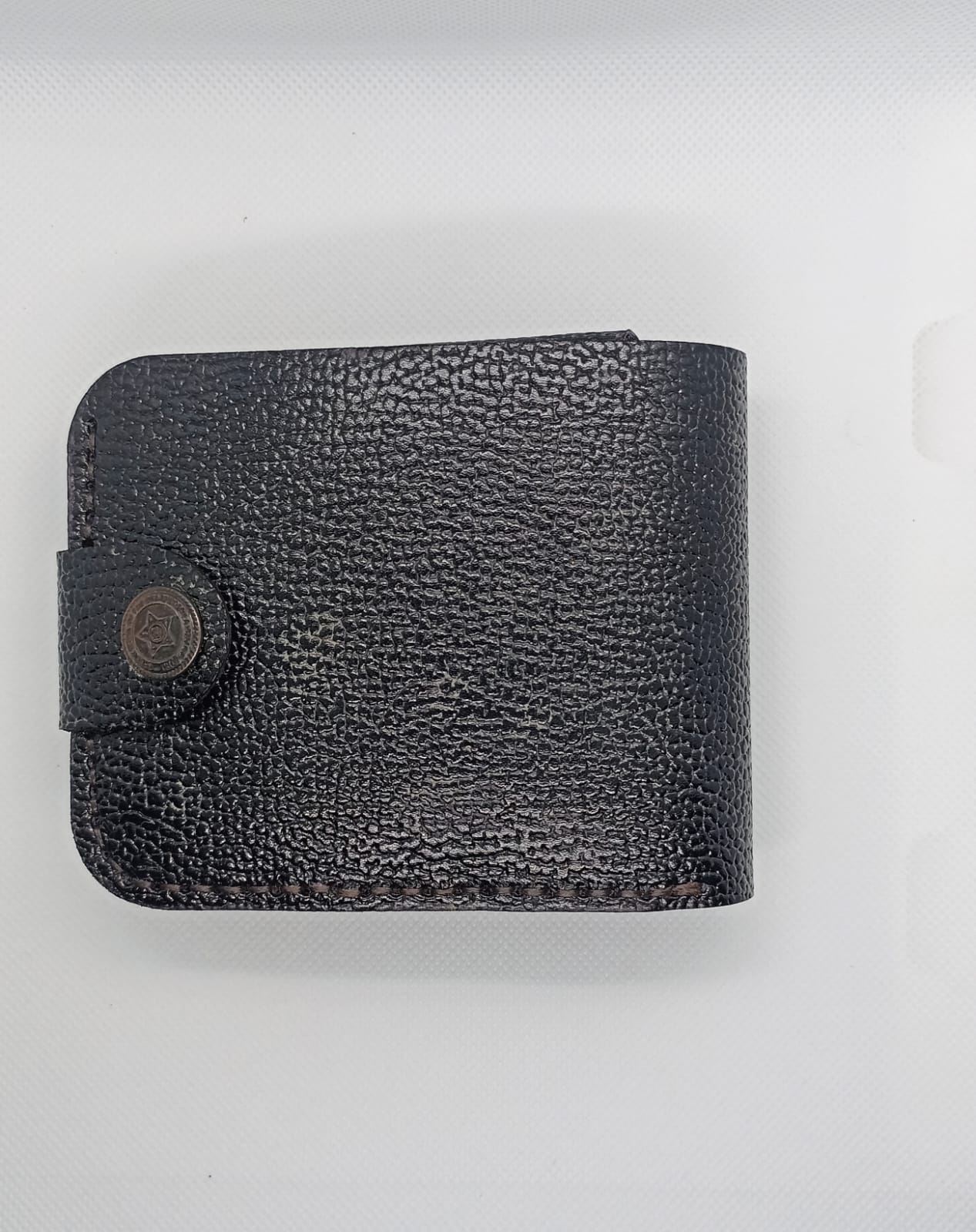 Black leather wallet on a light gray background